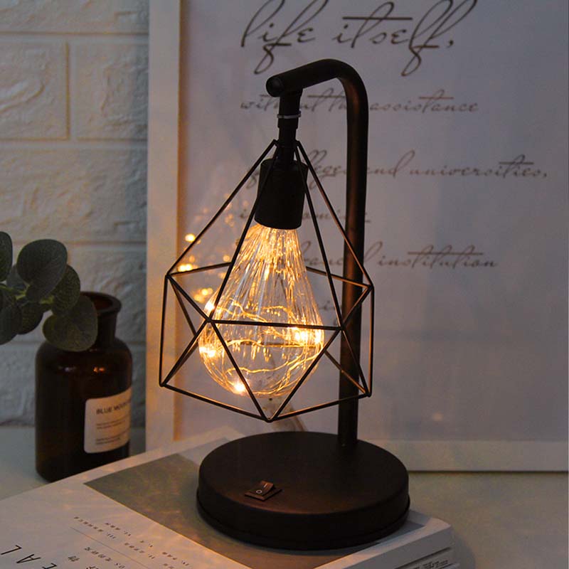 Black Geometric Loft LED Table Lamp on a table with a photo background