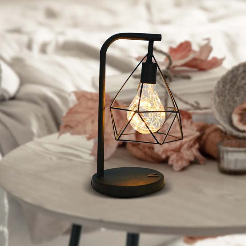Geometric Loft LED Table Lamp on a table against a backdrop of upholstered furniture