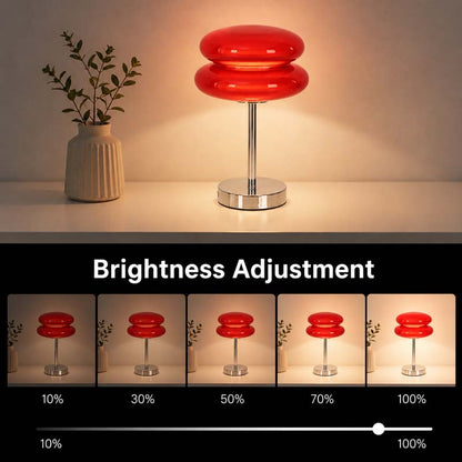 A Retro Sandwich Glass Table Lamp sits on a shelf next to a small houseplant. Beneath it is a graphic brightness control indicator.