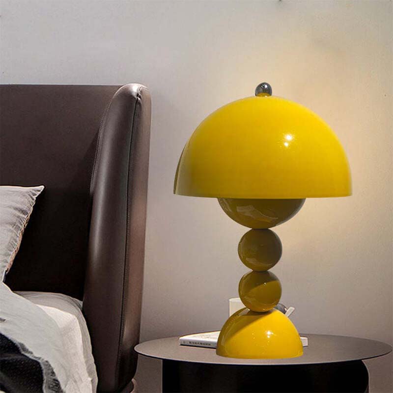 Yellow table lamp on a bedside table next to a bed