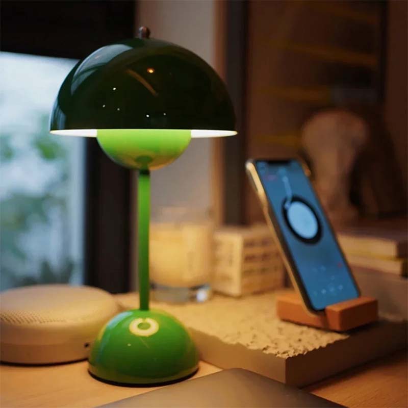 Green lamp on a desk with a phone and blurred background