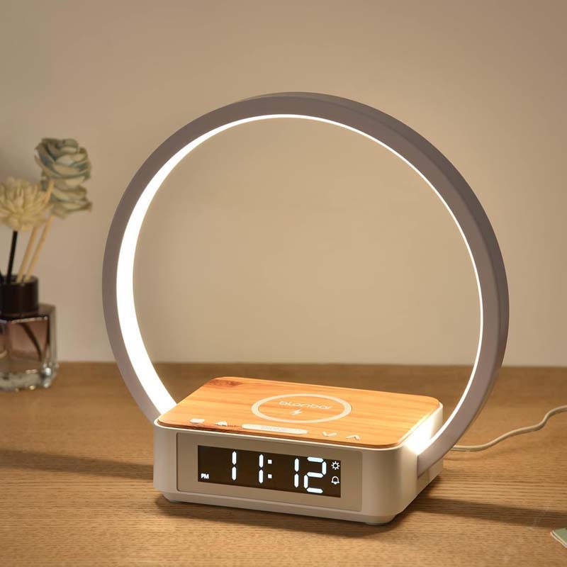 Modern alarm clock with circular light on a wooden surface