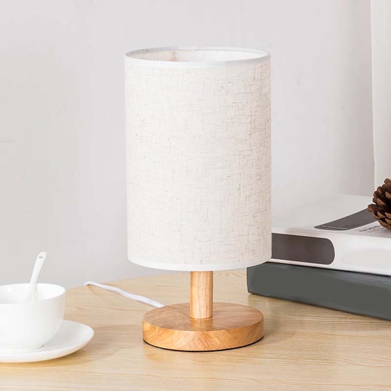 Wood Table Lamp with Natural Fabric Shade on a table with a cup of tea
