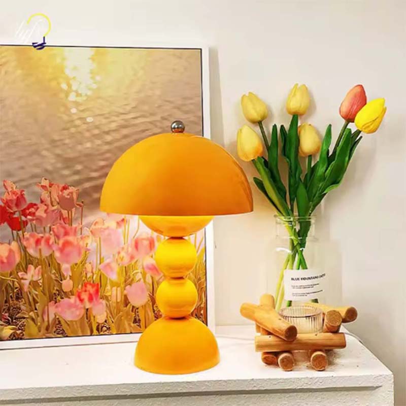 Yellow lamp on a table with flowers and a painting in the background