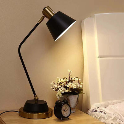 The Modern Adjustable LED Reading Desk Lamp sits on a wooden nightstand next to a small black alarm clock and a vase of flowers.