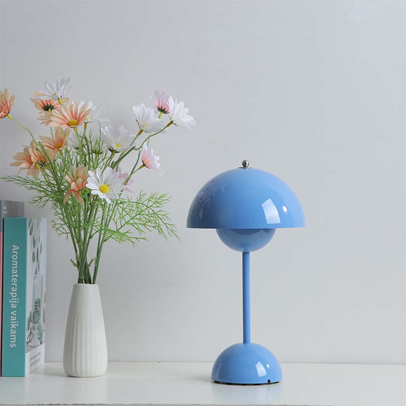 Blue table lamp and white vase with flowers on a light gray background
