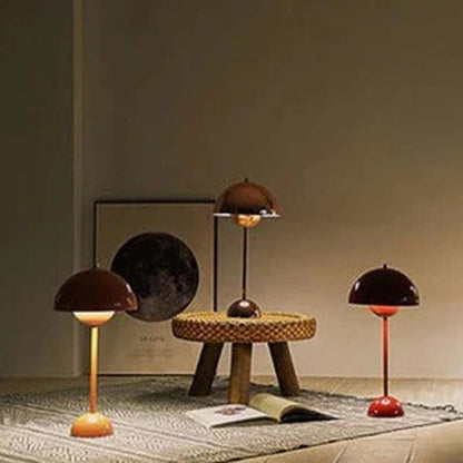 Three unique lamps on a floor with a neutral background