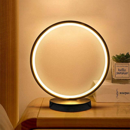 Warm glowing ring lamp on a wooden nightstand in a cozy interior setting