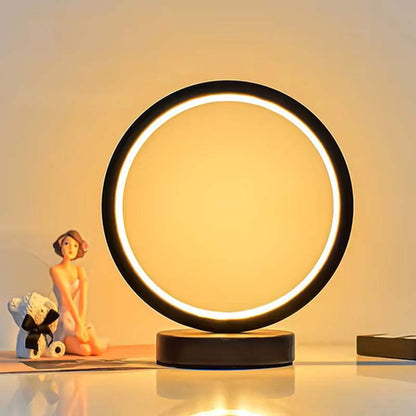 Stylish LED ring lamp on desk, modern accent lighting, warm soft light, decorative table lamp for bedroom or living room