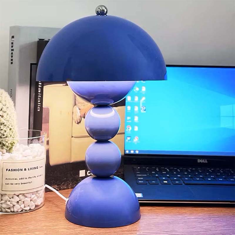 Blue lamp on a desk with a laptop in the background