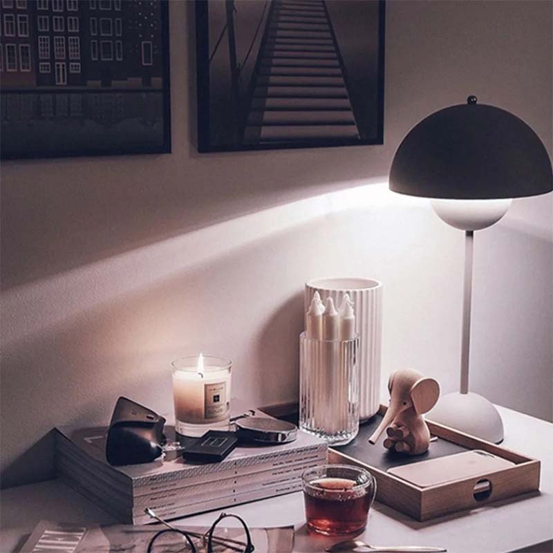 Cozy evening setting with a lit candle, glass of tea, and decorative items on a table.