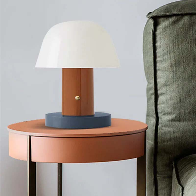 The Nordic Mushroom LED Table Lamp sits on a round side table next to the green sofa.