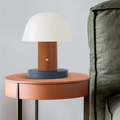 The Nordic Mushroom LED Table Lamp sits on a round side table next to the green sofa.