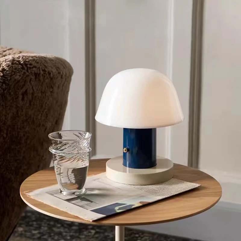 Nordic Mushroom LED Table Lamp is depicted on a small round table against a blurred landscape.