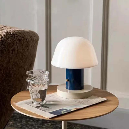 Nordic Mushroom LED Table Lamp is depicted on a small round table against a blurred landscape.
