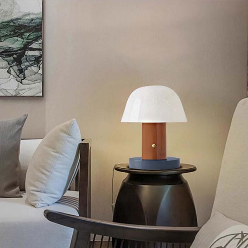 Nordic Mushroom LED Table Lamp sits on a dark bedside table in a cozy living room setting.