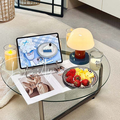 Nordic Mushroom LED Table Lamp stands on a glass coffee table with a tablet on a stand, with candles, a plate of strawberries and fruits
