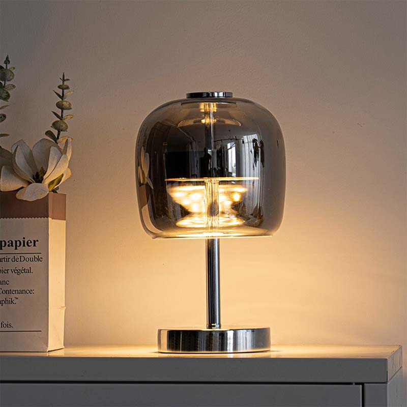 Premium Glass LED Table Lamp is placed on a white bedside table next to a decorative book.