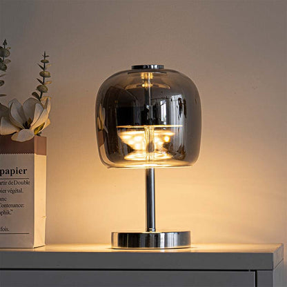 Premium Glass LED Table Lamp is placed on a white bedside table next to a decorative book.