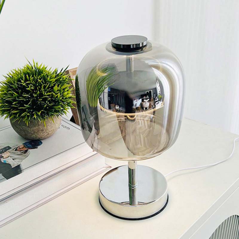 The Premium Glass LED Table Lamp is shown on a white tabletop next to a small potted houseplant.