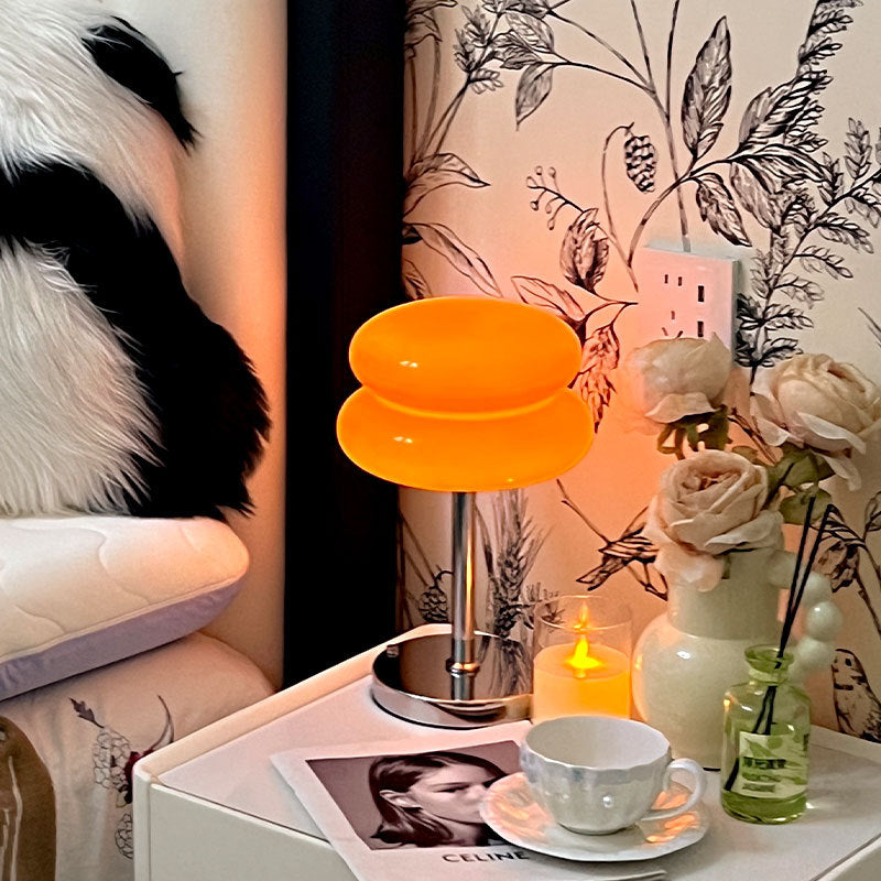 Retro Sandwich Glass Table Lamp placed on a white nightstand next to a mug, candle and floral decor.