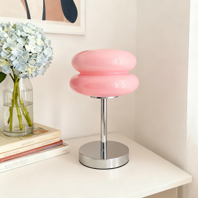 Retro Sandwich Glass Table Lamp placed on a white shelf next to a vase of hydrangeas.