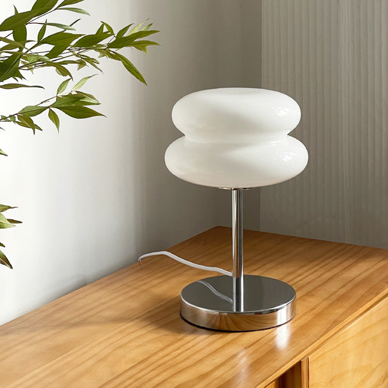 Retro Sandwich Glass Table Lamp placed on a wooden sideboard next to a green plant.