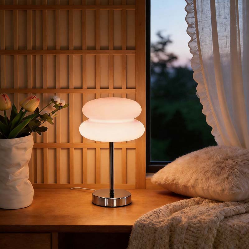 Retro Sandwich Glass Table Lamp placed on a wooden table next to a vase of tulips and a cozy throw pillow.