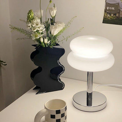 Retro Sandwich Glass Table Lamp with Flower Vase and Mug on White Surface.
