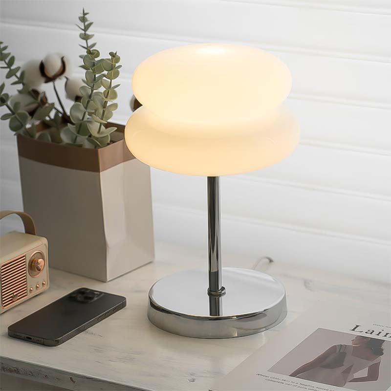 Retro Sandwich Glass Table Lamp placed on a marble tabletop next to a smartphone, a small retro radio and a houseplant.