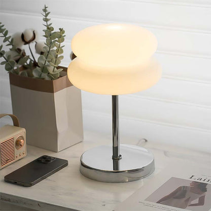 Retro Sandwich Glass Table Lamp placed on a marble tabletop next to a smartphone, a small retro radio and a houseplant.