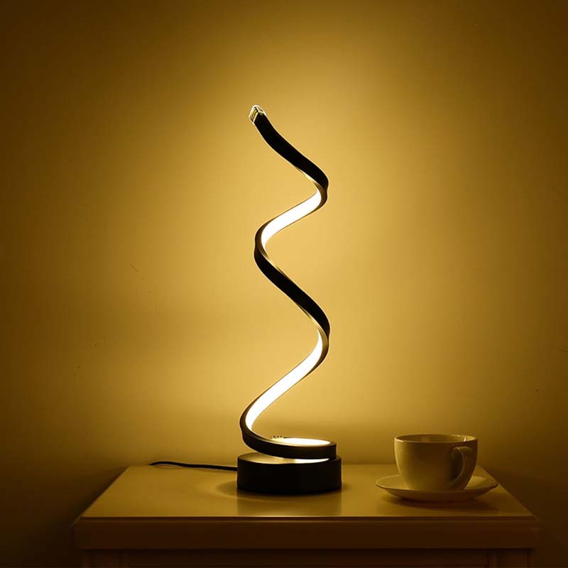 Spiral lamp on a table with a cup and saucer against a warm background