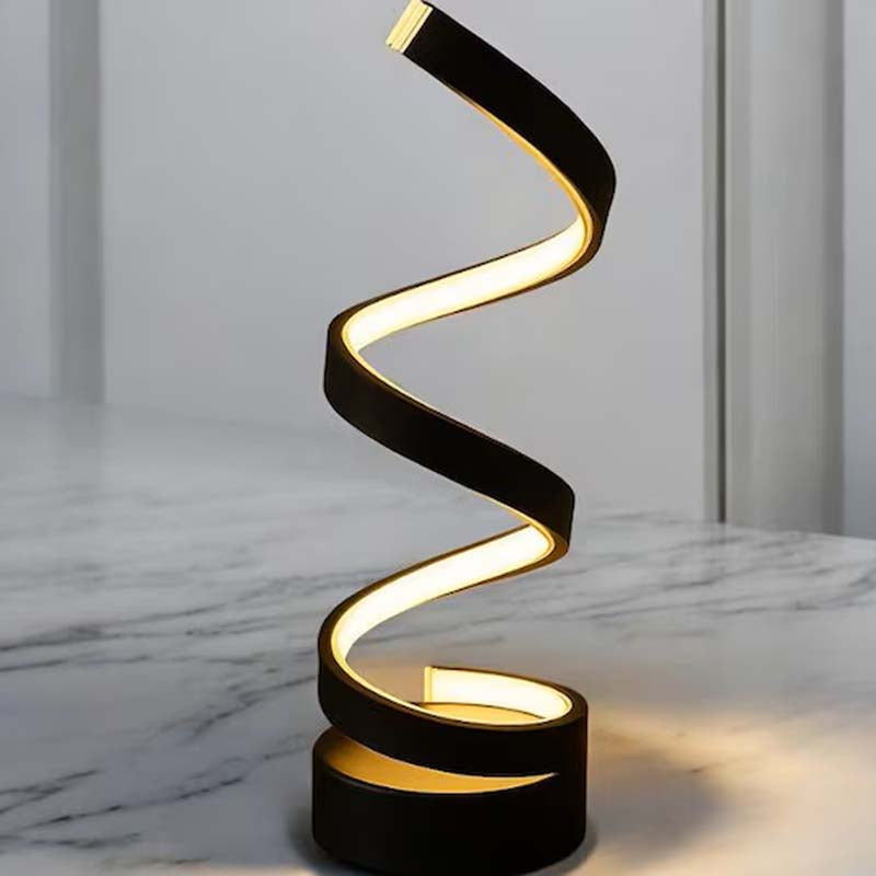 A modern spiral LED table lamp with a black frame and warm yellow light, standing on a marble surface against a light gray background.