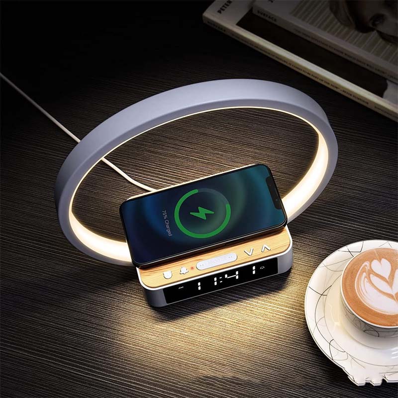 Wireless charger with a smartphone on a wooden surface next to a cup of coffee.