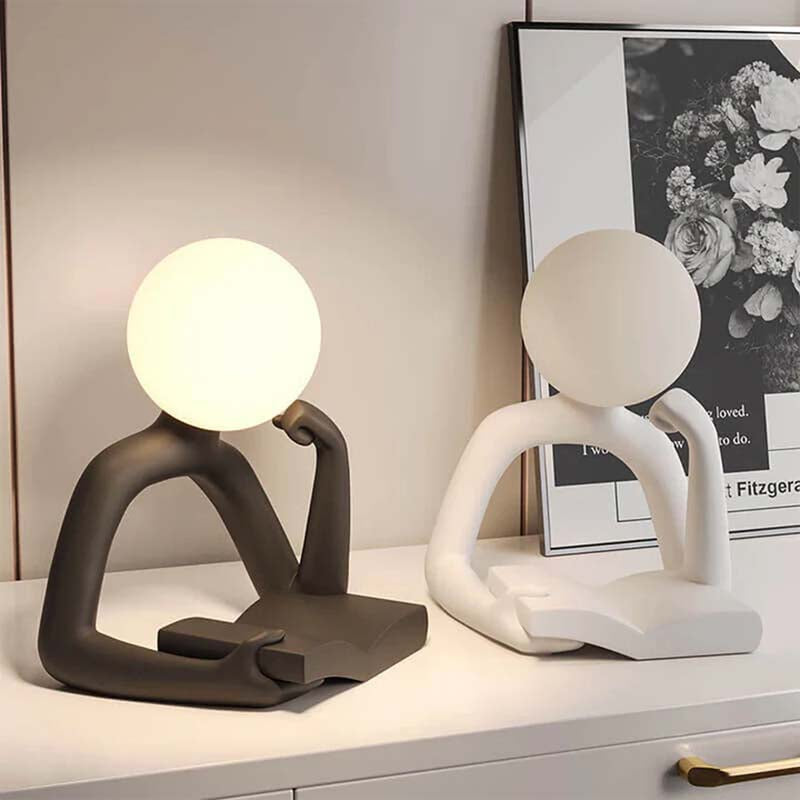 Two modern Thinker Statue LED Table Lamps with abstract patterns stand on a surface.