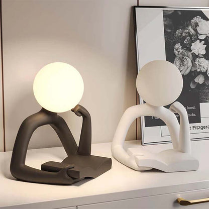 Two modern Thinker Statue LED Table Lamps with abstract patterns stand on a surface.