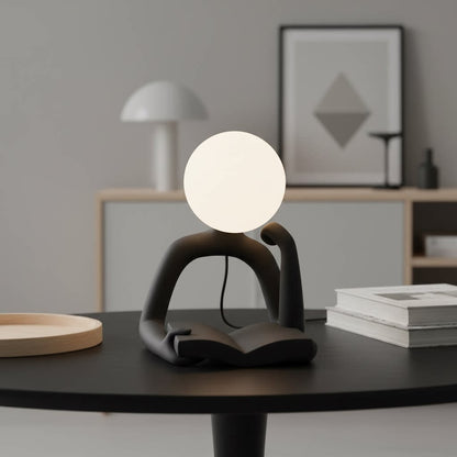 Thinker Statue LED Table Lamp, sits on a black table