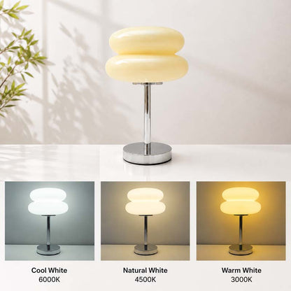 The Retro Sandwich Glass Table Lamp, shown lit on a tabletop. The three small images below show the lamp in three color modes.