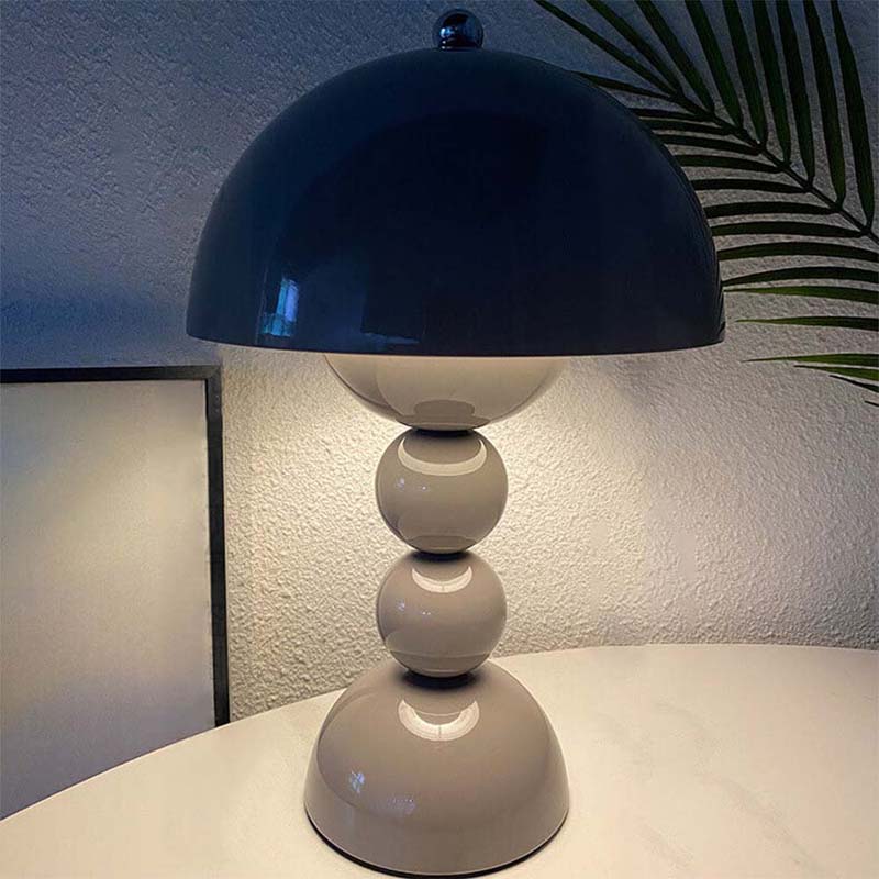 Table lamp with a dark blue shade and white base on a surface.