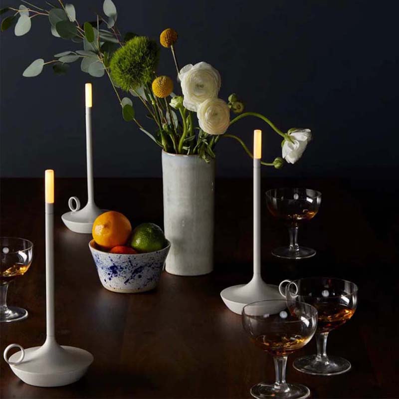 Decorative table setting with flowers, candles, and fruit on a dark background