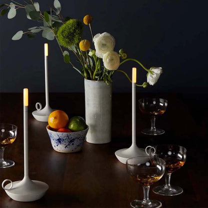 Decorative table setting with flowers, candles, and fruit on a dark background