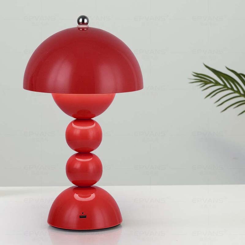 Red table lamp with a unique design on a white surface.