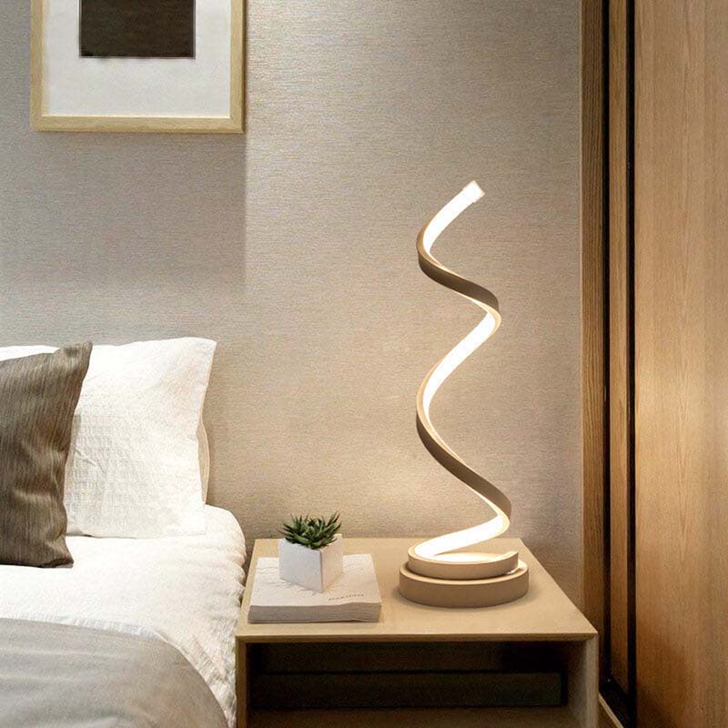 Modern LED Sculptural Spiral LED Table Lamp on a bedside table in the bedroom.