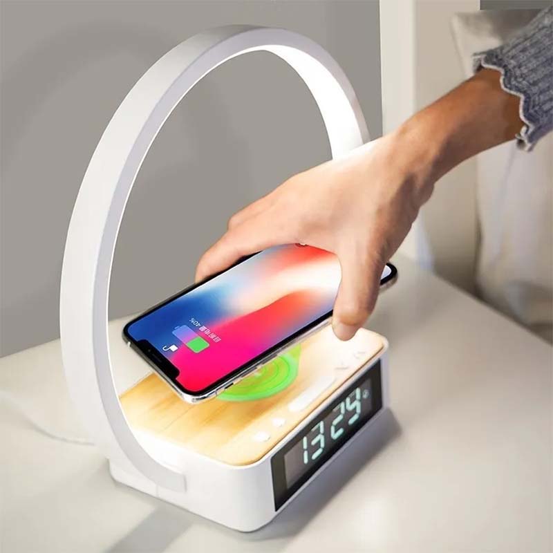 Table lamp with digital clock and wireless charging pad on a white surface